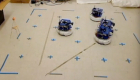 four robots on a floor in a grid 