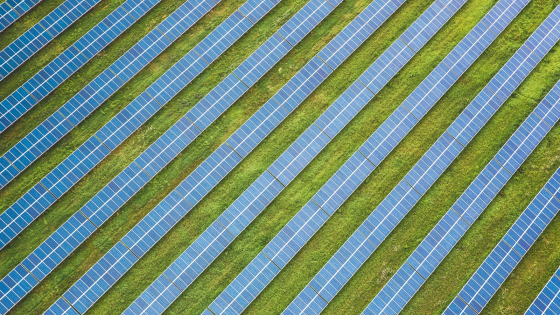 an aerial photo of a field of many rows of solar energy arrays 