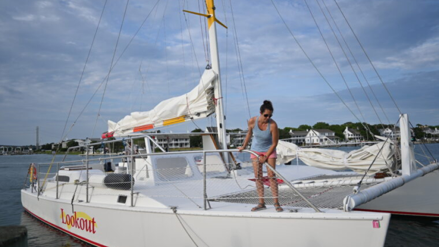 A woman prepares a sailboat for a voyage.