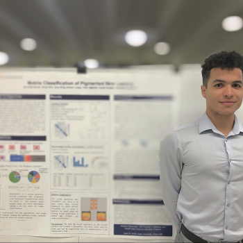 person stands in front of a research poster