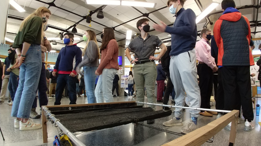 engineering students stand around a prototype automated gardening frame