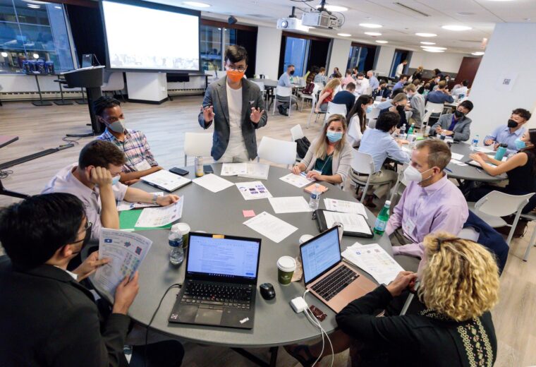 people work on laptop computers at a round table