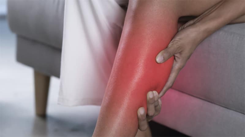 a person grabbing their lower leg that is glowing red