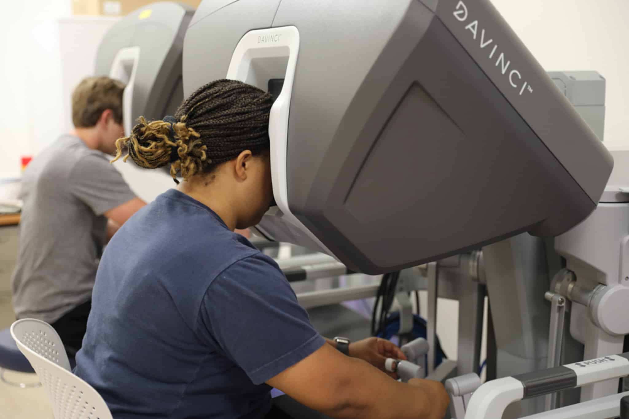 students work with robbotic surgery machines in lab