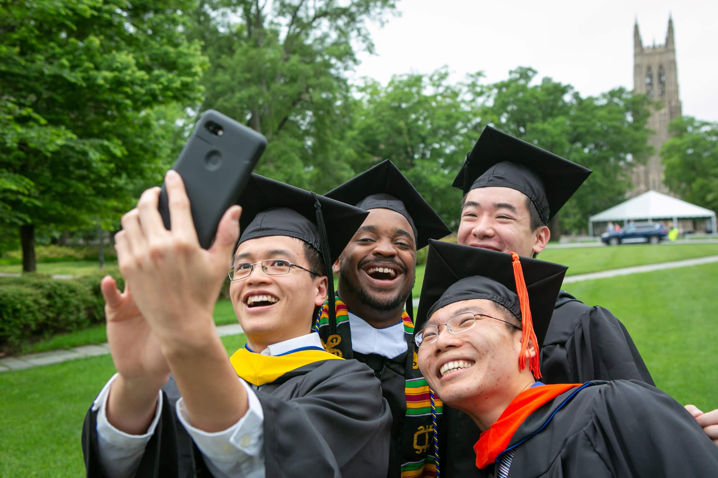 graduates take a selfie in front of Duke Chapel