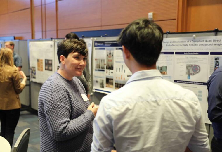 two people stand in front of research posters