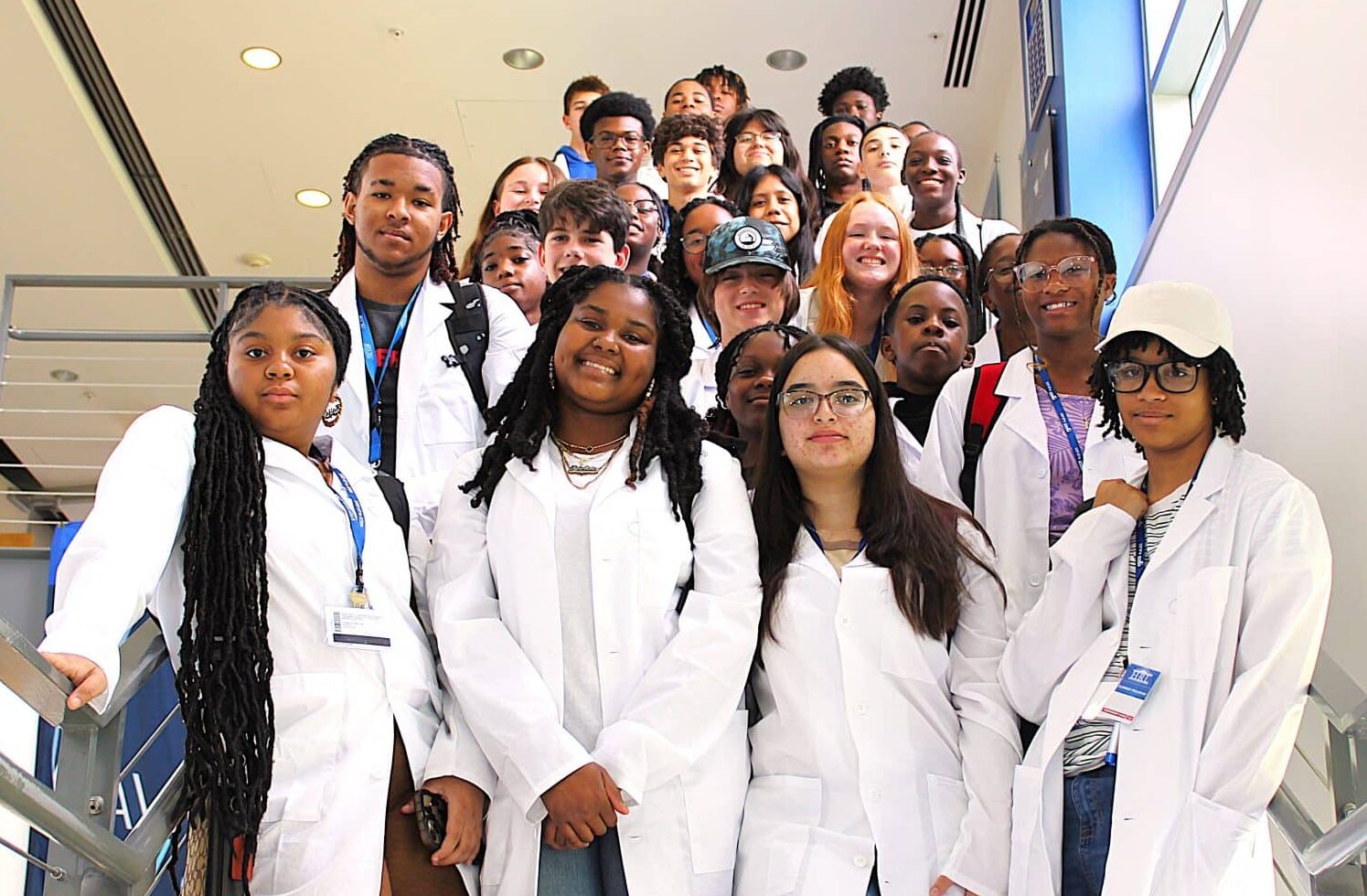 students pose in white lab coats