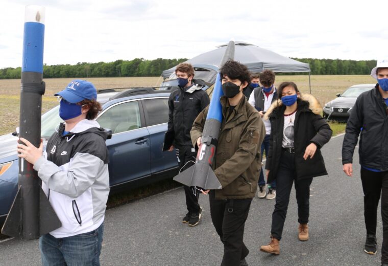 Engineering students carry model rockets