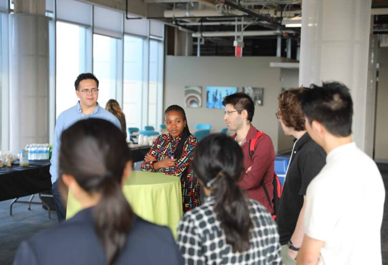 people stand around bistro tables